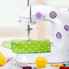 A close-up shot of a white and purple mini sewing machine with green polka dot fabric underneath. Produktbild-Vorschau
