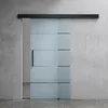 A modern sliding glass door with frosted stripes against a concrete wall. Produktbild-Vorschau