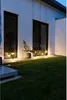 A modern house exterior at night, with outdoor lighting illuminating the lawn and windows. Produktbild-Vorschau