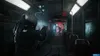 A person in a hazmat suit aims a weapon down a dark, grimy train car. Produktbild-Vorschau