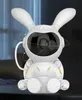 A white robotic bunny-shaped night light projector sits on a dark surface. Náhled obrázku produktu