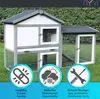 A wooden rabbit hutch with an attached run, set up on a grassy lawn. Produktbild-Vorschau