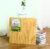 A stack of puzzle mats with a wooden texture, a small plant on a stool, and a stack of books. Produktbild-Vorschau