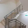 A staircase with metal railings and beige steps. Produktbild-Vorschau