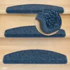 Close-up view of blue stair mats on wooden stairs, with a magnified section showing the texture of one mat. Produktbild-Vorschau