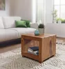 A living room scene with a couch, coffee table, and rug. Produktbild-Vorschau
