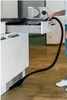 A person is using a vacuum cleaner hose to clean out a kitchen drawer. Podgląd zdjęcia produktu