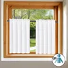 A window with white curtains and a view of a garden outside. Produktbild-Vorschau