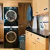 A laundry room with a stacked washer and dryer, cabinets, and ironing supplies. Produktbild-Vorschau