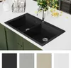 A black double basin kitchen sink with a chrome faucet is shown on a white countertop, with green cabinets below. Several swatches of different sink colors are displayed at the bottom. Náhled obrázku produktu