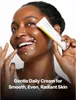 A woman is applying cream to her face, with dots of cream on her cheeks and chin. Podgląd zdjęcia produktu