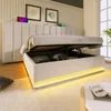 A bed with its storage compartment open, showing items inside, in a bedroom setting. Produktbild-Vorschau