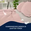A close-up view of pink bedding with decorative feathers and text overlay. Produktbild-Vorschau
