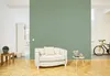 A living room scene with a couch, a small table with flowers, a cabinet, and a bicycle. Produktbild-Vorschau