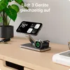 A 3-in-1 wireless charger for iPhone, Apple Watch, and AirPods is shown on a wooden desk next to a plant and keys. Produktbild-Vorschau