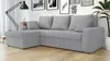 A gray sectional sofa with pillows in a living room setting, with framed pictures and a floor lamp in the background. Náhľad obrázku produktu