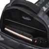 Close-up view of the inside of a black camouflage backpack, showing a laptop and a notebook. Náhled obrázku produktu