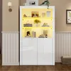 A white high-gloss display cabinet with illuminated shelves, filled with decorative items, is shown in a room setting. Produktbild-Vorschau