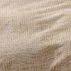 A close-up view of beige seersucker fabric with a subtle white pattern. Produktbild-Vorschau