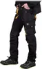 A person wearing black and yellow work pants and shoes, shown from the waist down. Produktbild-Vorschau