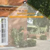 A SYLVANIA LED spotlight with a motion sensor mounted on a brick wall, illustrating its beam angle. Produktbild-Vorschau