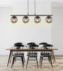 A dining table with chairs and a pendant light fixture above. Anteprima dell’immagine prodotto