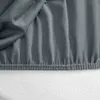 A close-up view of a dark gray fitted sheet with elasticized edges. Produktbild-Vorschau