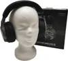 A pair of black gaming headphones is displayed on a white mannequin head, with the product's packaging visible in the background. Produktbild-Vorschau