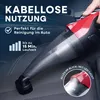 A hand is holding a red and black cordless vacuum cleaner, using it to clean a car seat. Produktbild-Vorschau