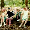 Four children are sitting on a log in a forest, each holding and looking through binoculars. Produktbild-Vorschau