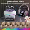 A humidifier with jellyfish-like mist and LED lights, shown with headphones and a phone playing music, suggesting its sound-reactive feature. Several smaller images at the bottom show different mist patterns. Produktbild-Vorschau