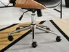 Close-up of the base of an office chair with wheels, resting on a rug. Voir les images du produit