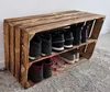 A wooden shoe rack made from crates, filled with shoes, placed against a wall on a rug. Náhled obrázku produktu