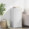 A white sideboard with a drawer and a cabinet door, placed next to a basket filled with items and a plant. Podgląd zdjęcia produktu