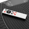 A close-up of a white remote control resting on a black textured surface, likely a vibration plate. Voir les images du produit