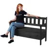 A woman is sitting on a dark wooden garden bench with storage. Anteprima dell’immagine prodotto