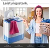 A woman is holding a laundry basket next to a mini washing machine. Produktbild-Vorschau