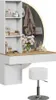 A white and wood vanity table with shelves, a round LED mirror, and a white stool, decorated with flowers and accessories. Voir les images du produit
