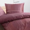 A close-up view of a bed with striped bedding. Produktbild-Vorschau