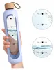 A hand holding a purple water bottle with measurement markings and time indicators. Náhľad obrázku produktu