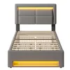 A grey upholstered bed frame with a slatted mattress base and integrated LED lighting. Produktbild-Vorschau