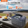 A portable car refrigerator is shown outdoors on a table with a scenic background of a lake and hills. Food items and drinks are also visible. Produktbild-Vorschau