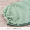 Close-up of a green sleeve with white and teal polka dots, featuring a gathered elastic cuff. Produktbild-Vorschau
