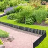 A garden path bordered by a black plastic edging, with lush green plants and flowers in the background. Náhled obrázku produktu