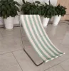A striped beach chair is shown on a tiled floor with potted plants in the background. Podgląd zdjęcia produktu
