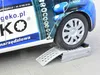 A car tire rests on a metal ramp on a paved surface. Náhled obrázku produktu