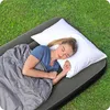 A woman sleeping on an air mattress outdoors on the grass. Náhled obrázku produktu