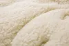 A close-up view of a fluffy, cream-colored material, likely a fabric. Anteprima dell’immagine prodotto