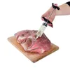 A hand is using a marinade injector to inject liquid into a large piece of raw meat on a wooden cutting board. Náhled obrázku produktu