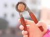 A hand holding a nutcracker with a walnut inside. Podgląd zdjęcia produktu